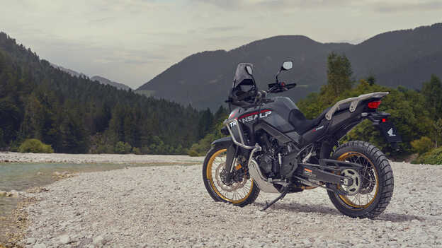 Egy motoros vezet egy XL750 Transalp motorkerékpárt hegyvidéki környezetben.