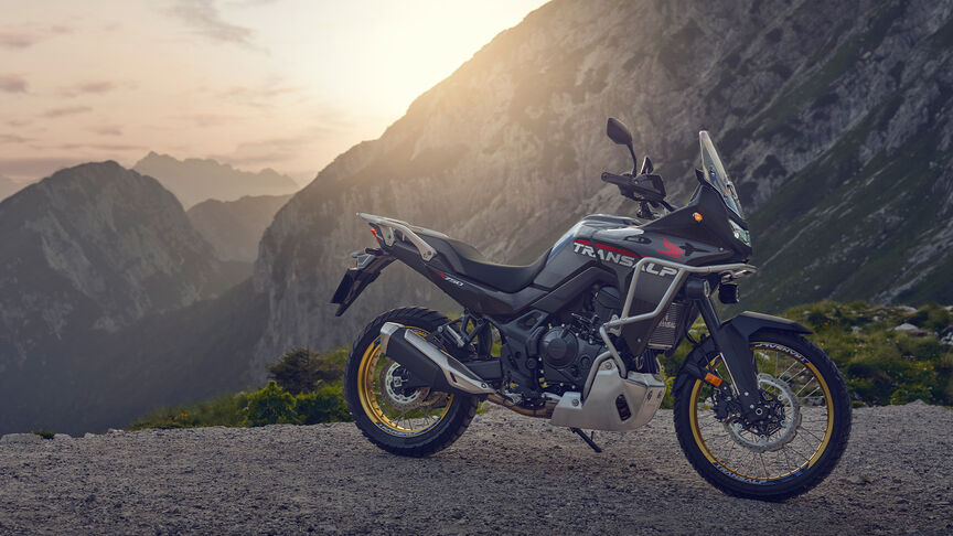 Modell vezet egy XL750 Transalp motorkerékpáron erdei környezetben.