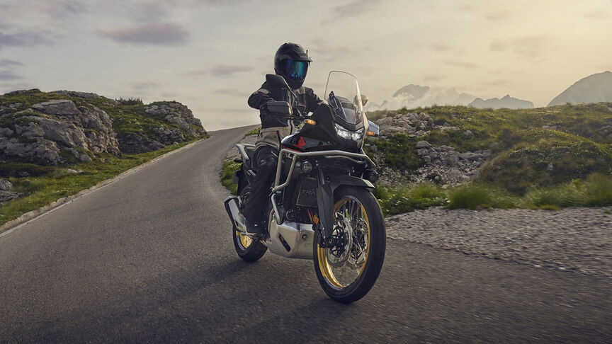 Modell vezet egy XL750 Transalp motorkerékpáron erdei környezetben.