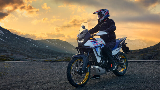 Modell egy XL750 Transalp motorkerékpáron közúton, hegyi környezetben.