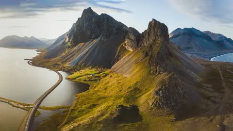 Festői út Izlandon, gyönyörű természeti tájkép, légi panorámakép, hegyek és tengerpart a naplementében