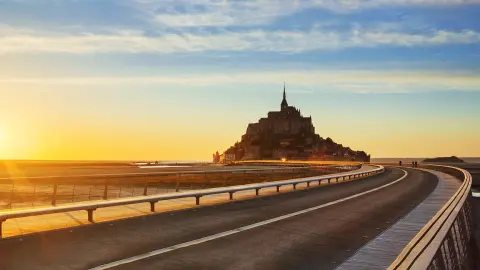 A Mont-Saint-Michelbe vezető út naplementekor, Normandiában. Franciaország.