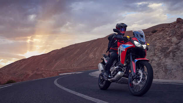 Az Africa Twin szemből, háromnegyedes nézetben, motorossal, közúton