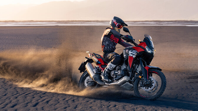Egy Honda CRF1100L Africa Twin, amely a sivatagban halad. 