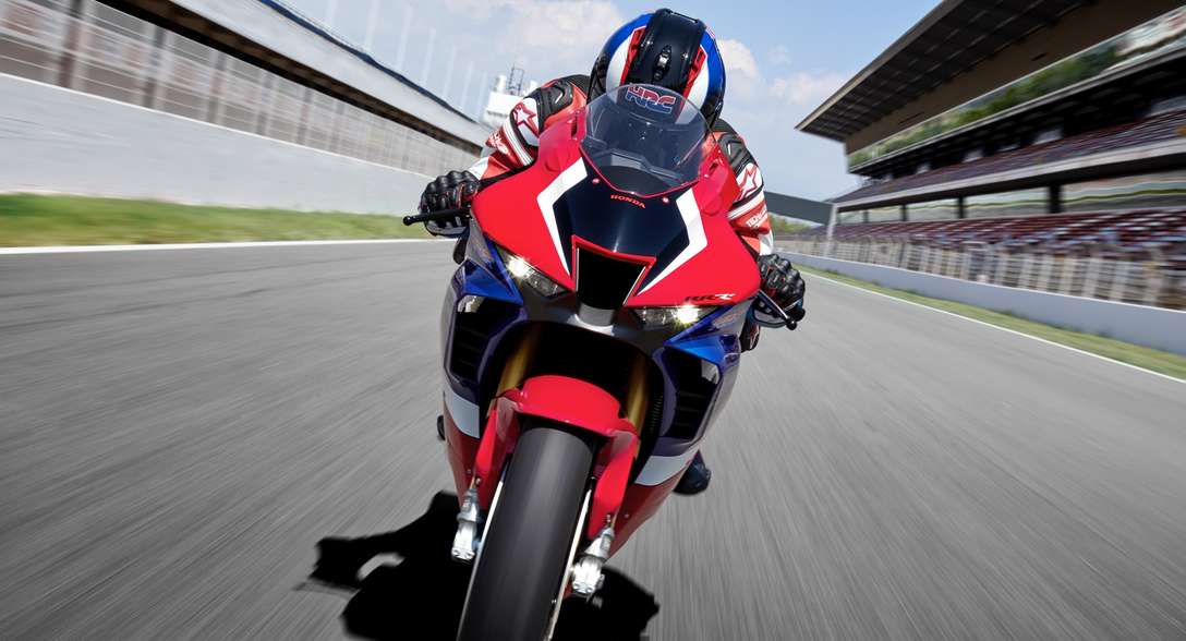 Elölről készült felvétel egy versenypályán száguldó Honda CBR1000RR-R Fireblade SP-ről, motorossal
