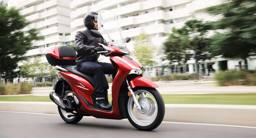 Honda SH125i, háromnegyedes, elölről készült felvétel, motoros a városban
