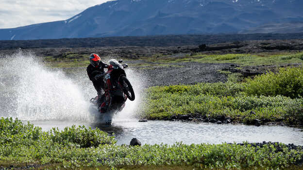 Kiran Mirabet egy Africa Twin nyergében, ahogy vízen halad át. 
