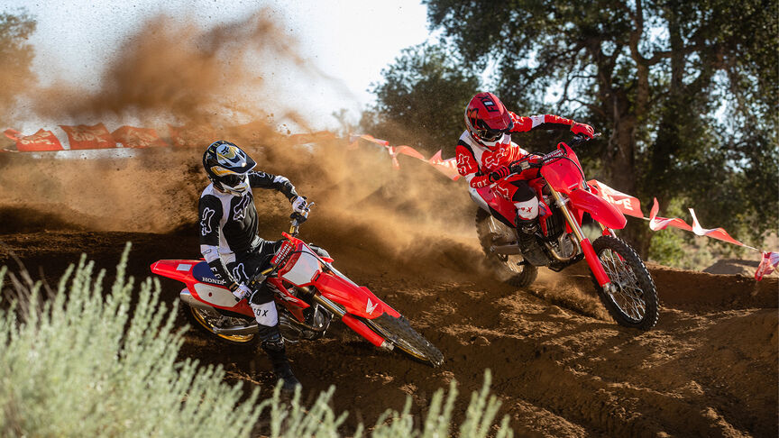 Két motoros ugratókon halad át a Honda CRF450R modellel.