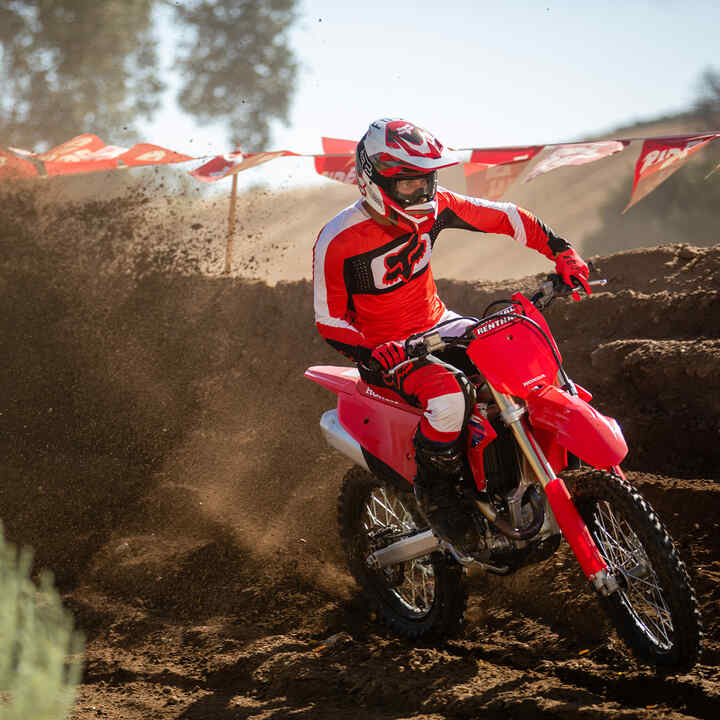 Egy Honda CRF450R, amellyel terepen haladnak, a háttérben hegyek.