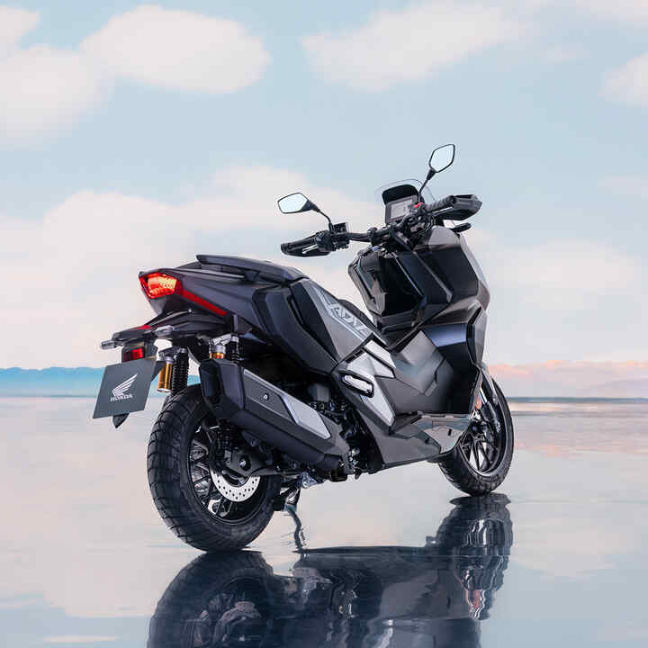 Hátulról készült háromnegyedes felvétel a Honda ADV350 modellről tengerparti környezetben. 