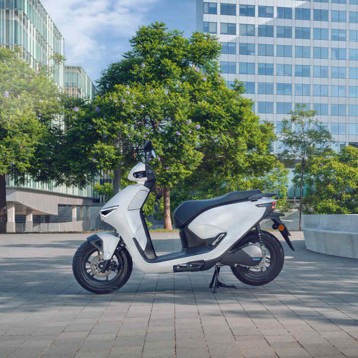 Honda CUV e motorkerékpár parkol városi környezetben.