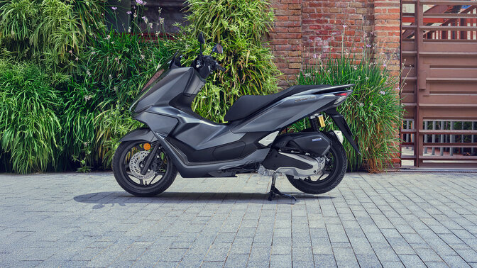 PCX 125 motorkerékpár egy park mellett leállítva.