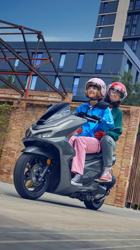 Fotómodellek PCX125 motorkerékpáron, városi környezetben.