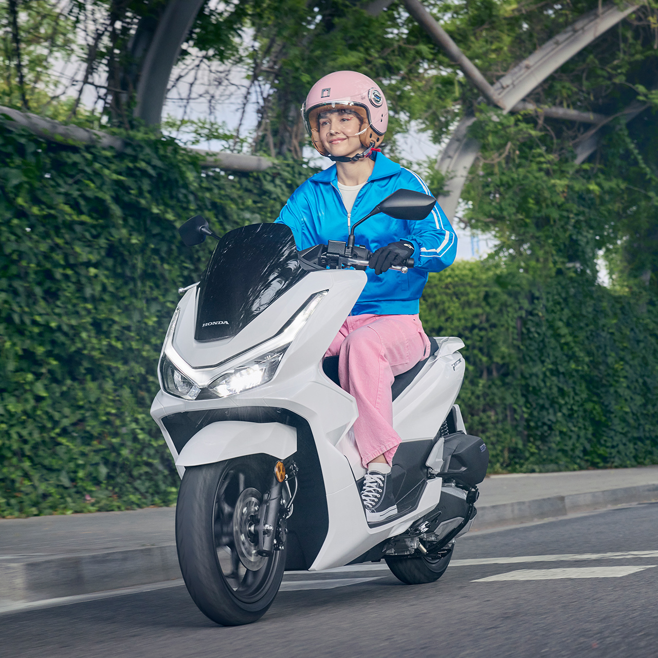 Fotómodell egy PCX125 motorkerékpár nyergében, városi környezetben