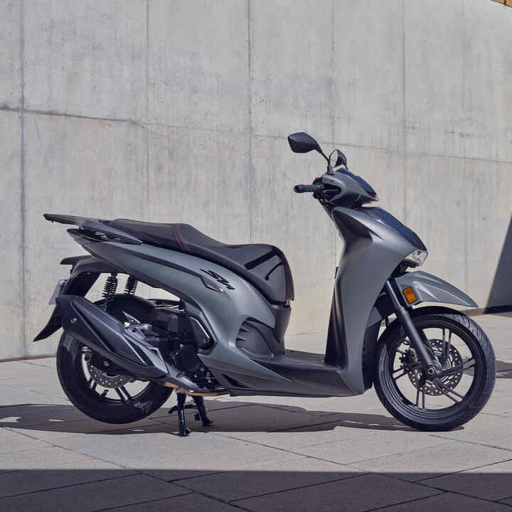 Két parkoló Honda SH350i egy épület előtt. 