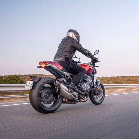 Honda CB1000R, háromnegyedes felvétel jobb hátulról, motorossal, az úton