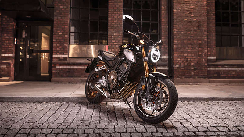 Háromnegyedes, elölről készült felvétel a CB650R Neo Sports Café jobb oldaláról városi környezetben éjszaka