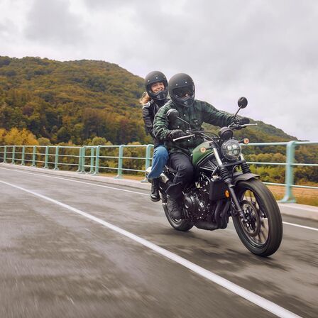 Honda CL500 közúton, motorossal és utassal.