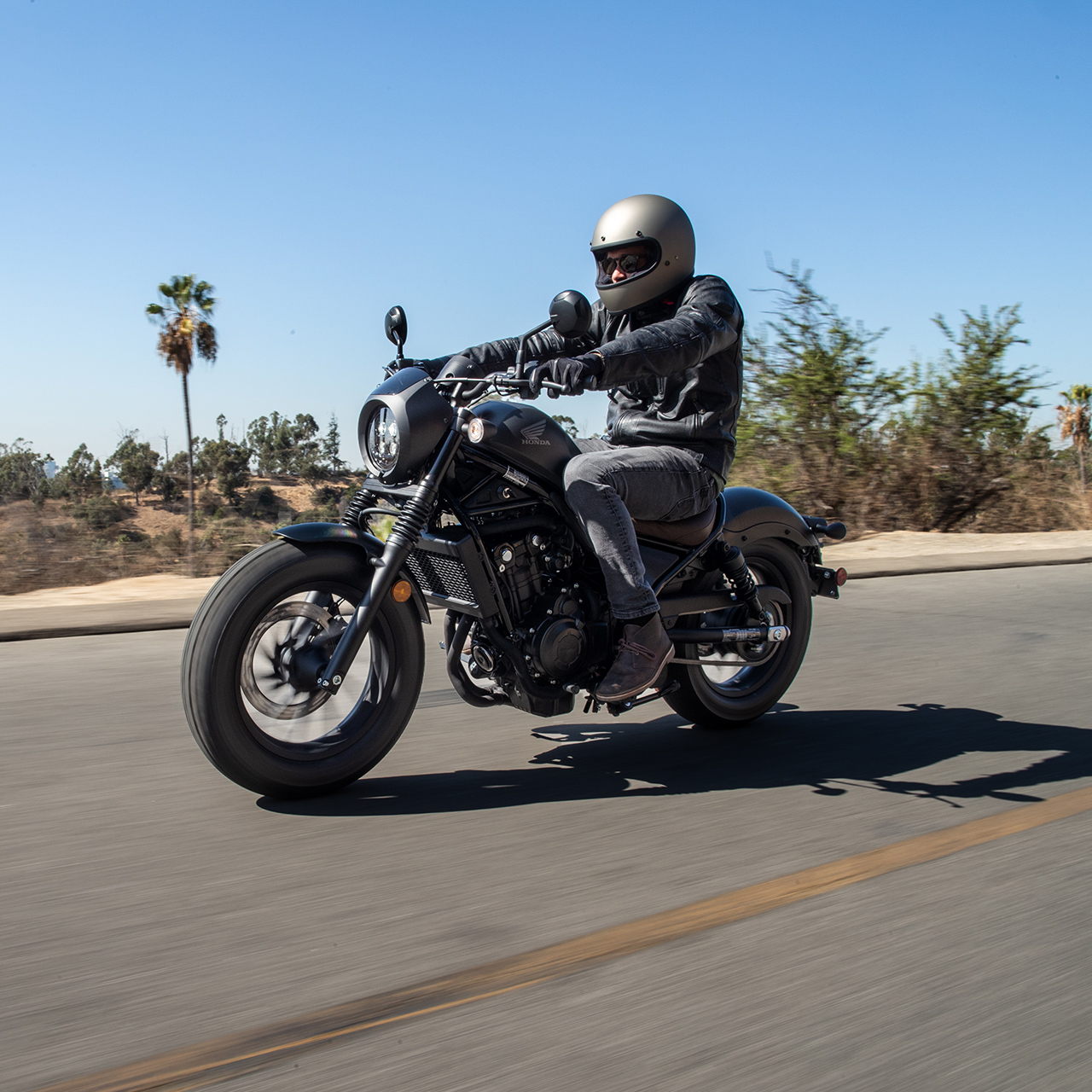 Honda CMX500 Rebel férfi motorossal utcai környezetben. 