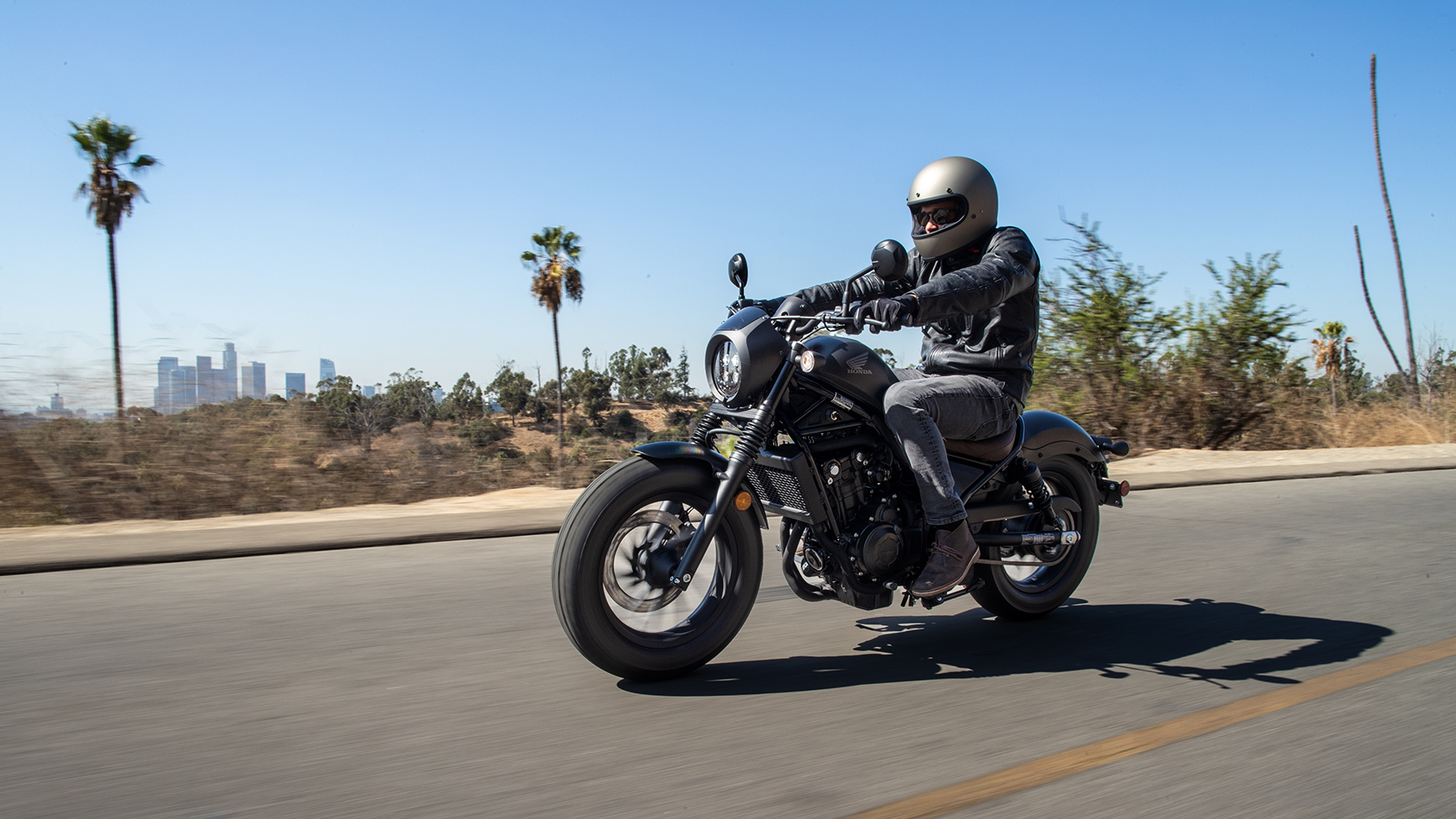 Honda CMX500 Rebel férfi motorossal utcai környezetben. 