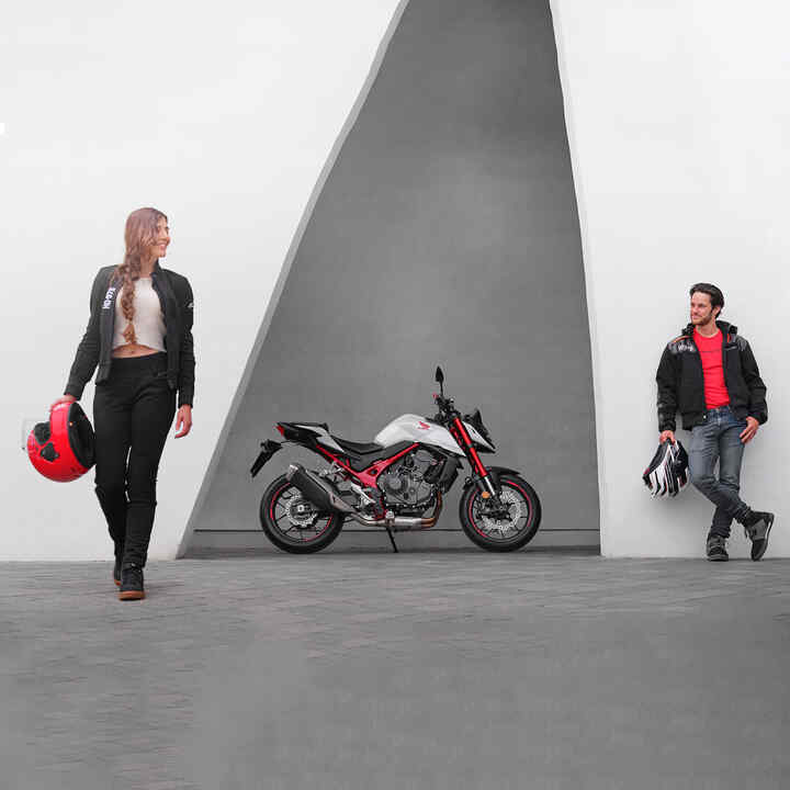 Egy férfi és egy nő a Honda CB750 Hornet mellett támaszkodik.