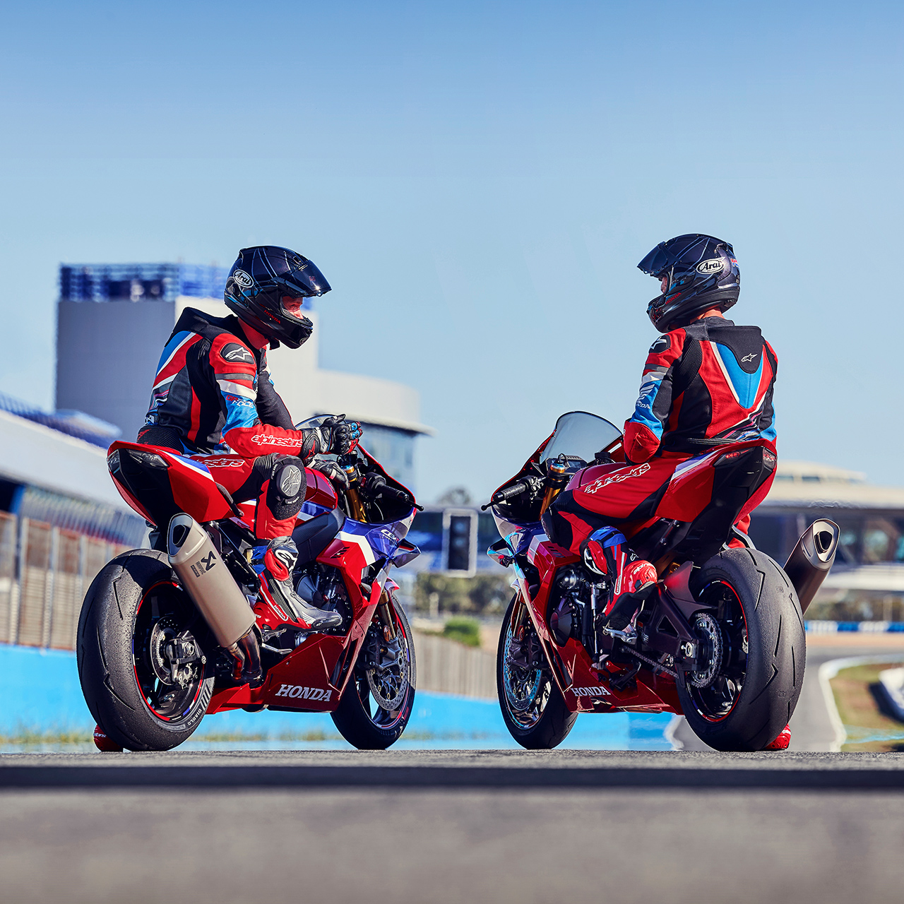 Két motoros a Honda CBR1000rr-r Fireblade nyergében egy versenypályán, hátulról. 