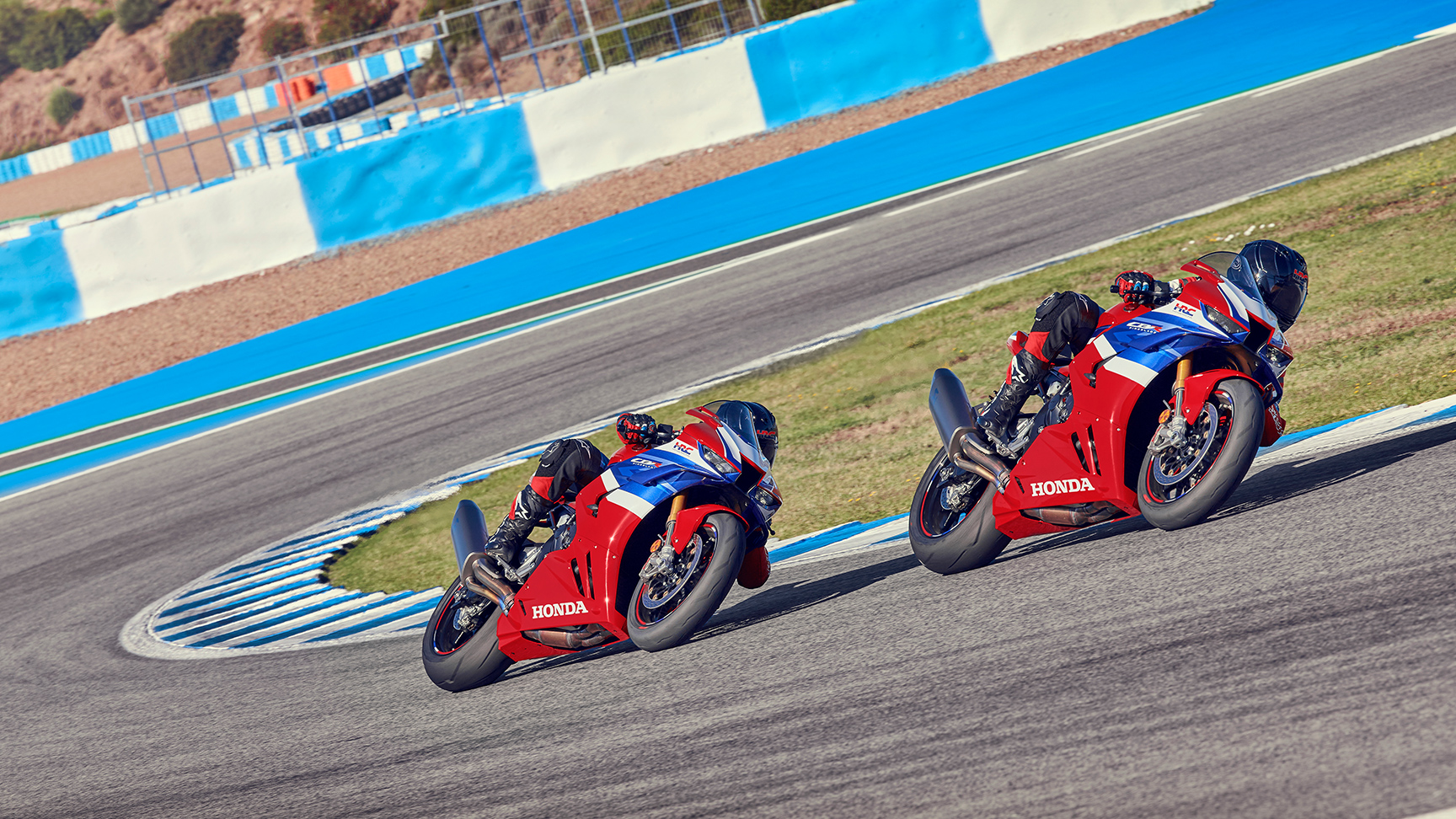 Két motoros a Honda CBR1000rr-r Fireblade nyergében versenypályán, a kanyar közepén