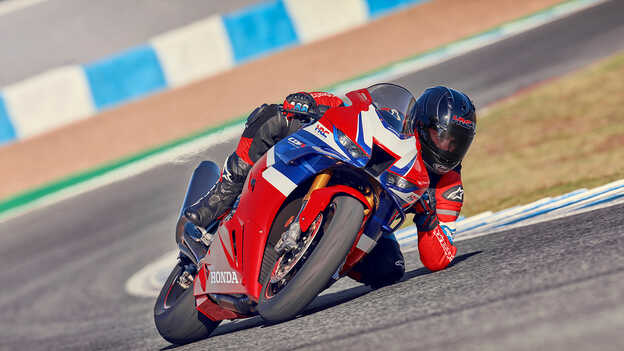 Honda CBR1000rr-r Fireblade – dinamikus felvétel a versenypályán motorossal, amint épp a kanyarból gyorsít ki.