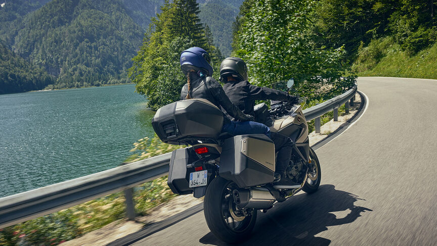 Az NT1100 oldalnézetből, motorossal, városi környezetben